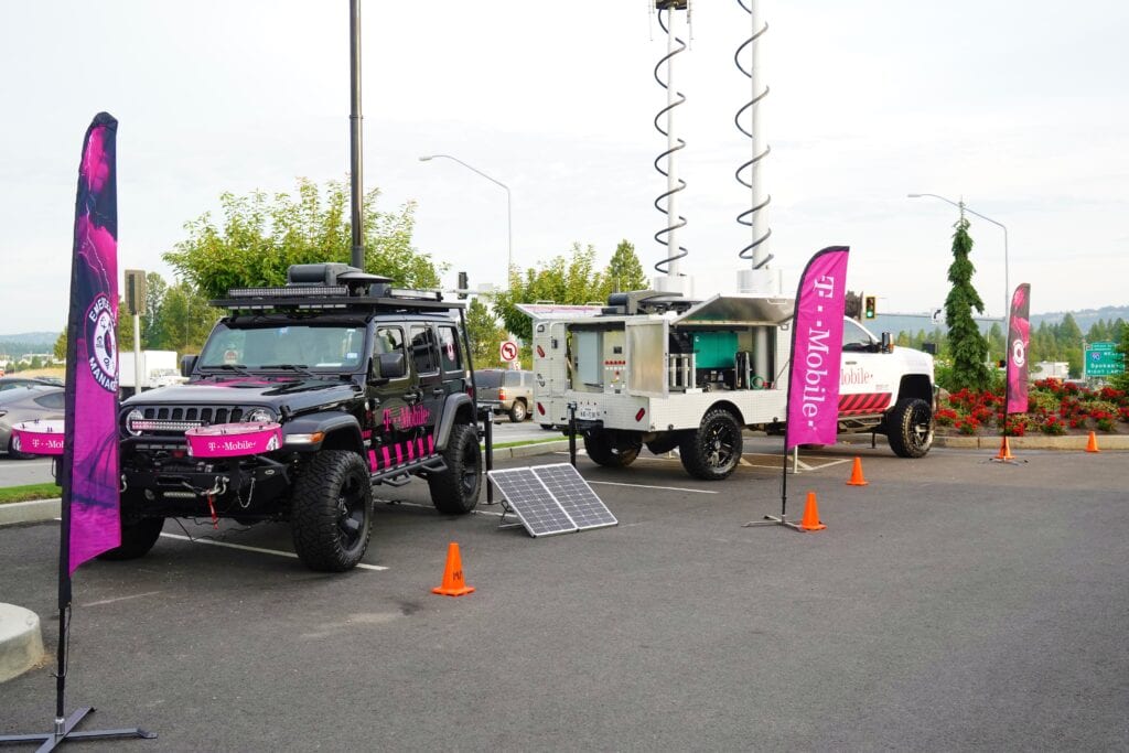 Two heavy duty vehicles parked back-to-back outdoors, branded with the mobile365 logo. Vehicle on the right of the image has satellite equipment extended