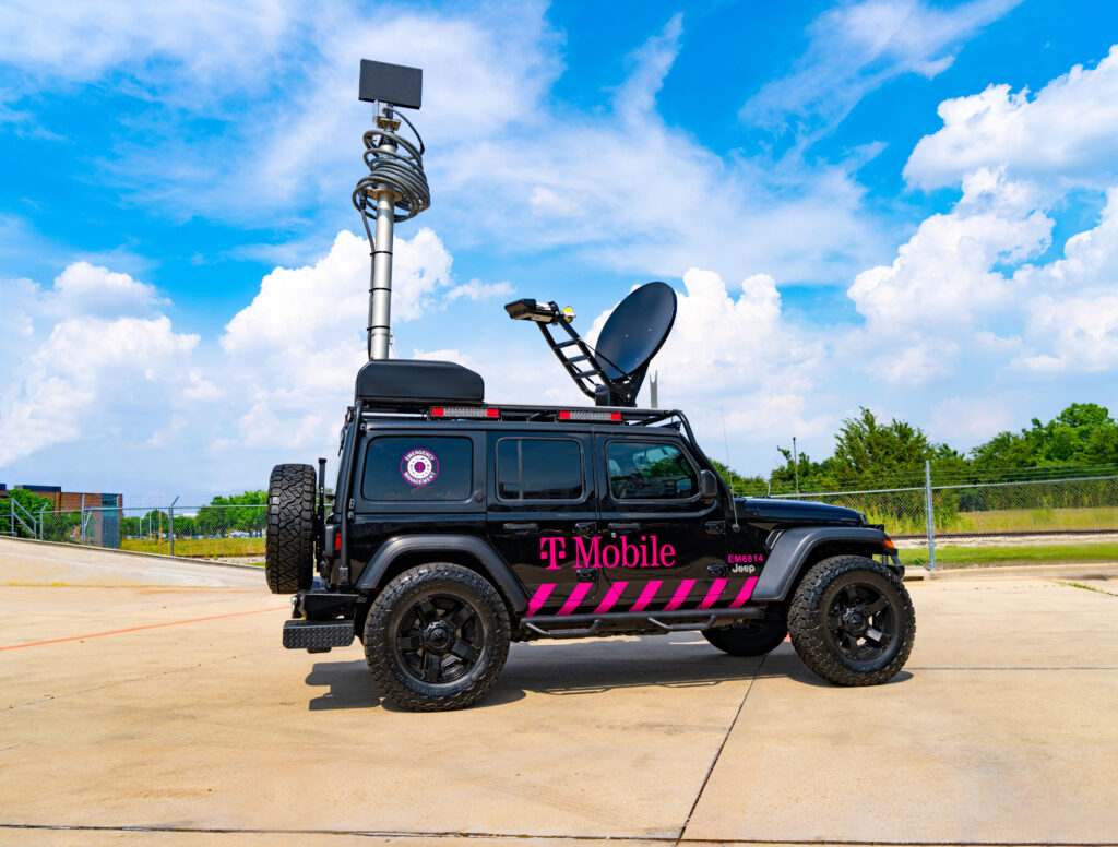 mobile365 logo branded all-terrain vehicle with mounted satellite equipment extended. Vehicle is parked outdoors